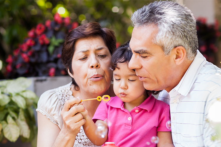 Grandparents and Granddaughter blowing bubbles