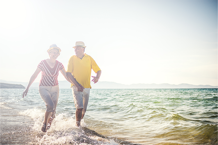 Couple walking through the waves on a beach