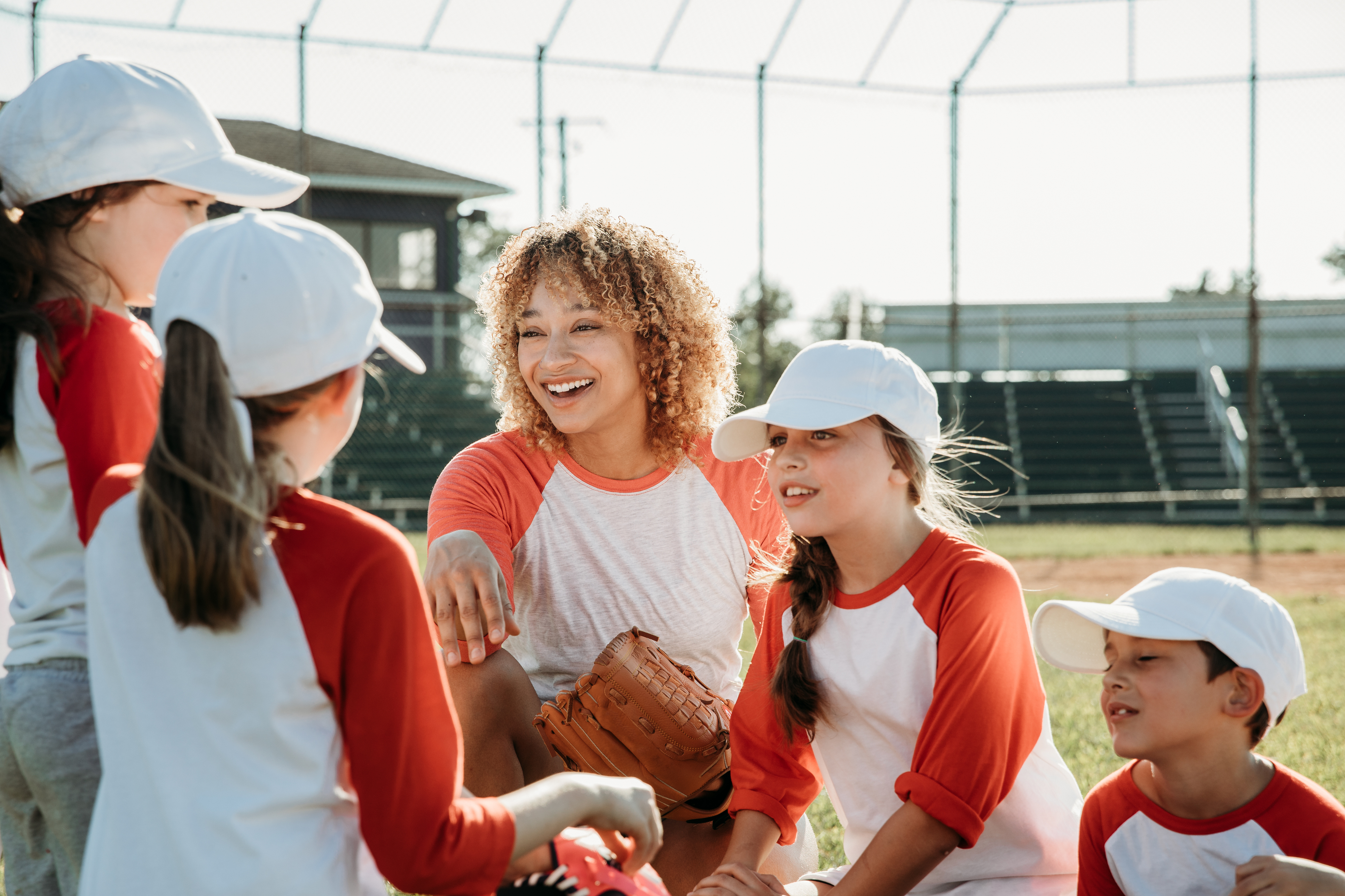 Woman coaching children in baseball
