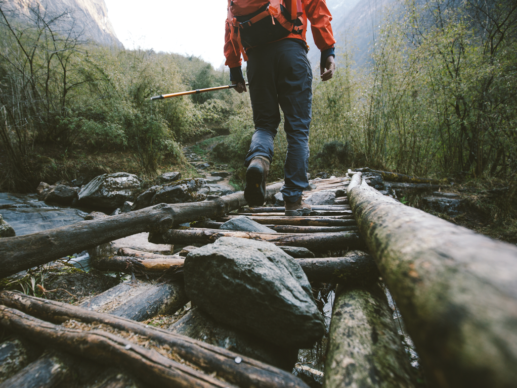 Person walking over bridge in the wilderness