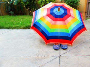 Photo of person sitting under an umbrella