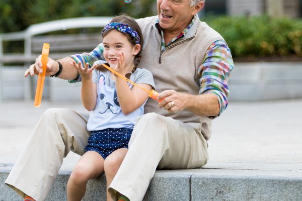 Grandfather and grand daughter blowing bubbles